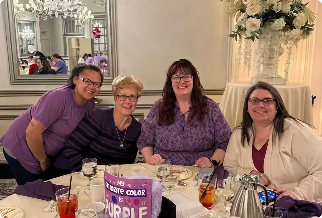 Smiling women in purple outfits